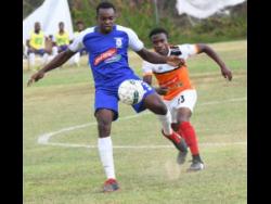Rondell Morris (left) of Reno and Nickoy Christian of Dunbeholden vie for the ball during their Red Stripe Premier League match on Sunday, March 10, 2019.