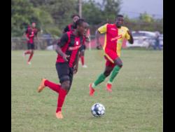Kemal Malcolm of Arnett Gardens moves away from Humble Lion’s Gregory Lewis during their RSPL encounter at Effortville in Clarendon yesterday.