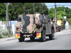 A Jamaica Defence Force vehicle is driven along Mountain View Avenue yesterday.