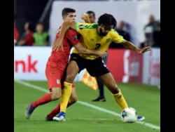 United States midfielder Christian Pulisic and Jamaica defender Michael Hector (right) battle for the ball during the second half of their Concacaf Gold Cup semi-final match in Nashville, Tennessee, on Wednesday, July 3, 2019. 