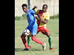 Portmore United’s Shai Smith (left) shields the ball from Humble Lion’s Levaughn Williams during their Red Stripe Premier League match at the Spanish Town Prison Oval on Sunday. 