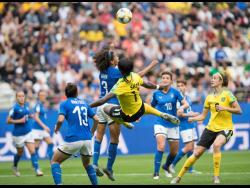 Jamaica’s Khadija Shaw (airborne) attempts an acrobatic shot that was contested by Italy’s team captain Sara Gama (3)  during their FIFA Women’s World Cup group stage match on June 14, 2019. Jamaica’s Havana Solaun (right) and Italy’s Elisa Bartoli (13) look on.