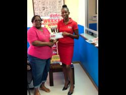 Maxine Smith, a winner in THE STAR’s Weekend Winninz competition, collects her is $10,000 prize money from Jodian Anderson, a clerical assistant at the Gleaner Company (Media) Limited’s Montego Bay office.  