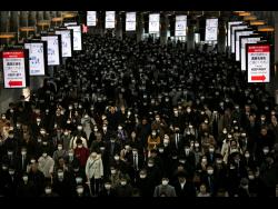 Persons all wearing masks commute through Shinagawa Station in Tokyo, Japan. The Japanese government has indicated it sees the next couple of weeks as crucial to containing the spread of COVID-19, which began in China late last year.