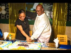 Birthday boy Lester ‘Father Ken’ Crooks cut his birthday cake with his sister, Carol Miller.