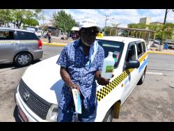 Credit: Kenyon Hemans Rupert Brown shows his hand sanitiser, part of his protective measure against COVID-19.