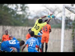 Tivoli Gardens’ goalkeeper Davian Watkins (#30) punches a corner kick clear of the goal in their Red Stripe Premier League fixture against Portmore United at the Spanish Town Prison Oval on March 1, 2020.