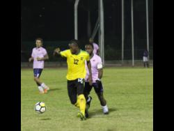 Jamaica forward Kemar Beckford (front) chases after the ball while being harried by Bermuda player Cecoy Robinson during their international friendly match at the Montego Bay Sports Complex on Wednesday, March 11.