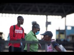 A elderly woman is seen exiting the Half Way Tree Transport Centre on Tuesday wearing a face mask. As of yesterday, public sector workers that are 65 and older are being asked to work from home were possible and all senior citizens 75 and older are required to stay home, one of several measures implemented by the Government in the fight against COVID-19.