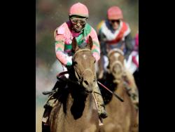 Jamaican jockey Rajiv Maragh reacts after riding Caleb’s Posse to victory in the Dirt Mile race at the Breeders’ Cup horse races at Churchill Downs in Louisville, Kentucky in 2011.