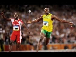 Jamaica’s Usain Bolt celebrates winning the gold medal in the men’s 100m final during at the Olympic Games at the Bird’s Nest Stadium in Beijing, China, on Saturday, August 16, 2008. At left is Trinidad’s Richard Thompson.
