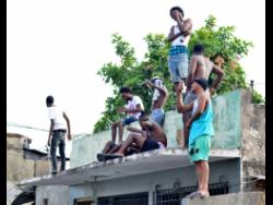 Denham Town residents gathered on a roof.