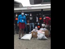 The Level Up Entertainment team hands over its donation of food and essential supplies to Mavis Farquharson, manager of the Marie Atkins Night Shelter on Hanover Street in Kingston.