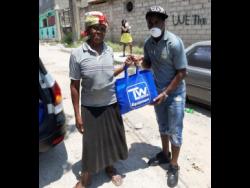 Audrey Robinson of Waterhouse receiving a care package from Waterhouse FC star player Tremaine Stewart.
