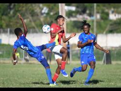 Dunbeholden FC’s Kemoy Atkinson (left) gets a toe to the ball ahead of UWI FC’s Thorn Simpson, while teammate Shaquille Dyer tracks back during their Red Stripe Premier League game at the UWI Mona Bowl on Sunday, January 12.