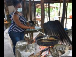 Michelle Fritz prepared fish for her customers in Scotts Cove, which sits on border of St Elizabeth and Westmoreland last Friday. She said that with the easing of the curfews, this is now their Easter as sales are gradually improving.