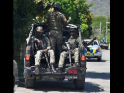 Jamaica Defence Force soldiers on patrol in August Town last Wednesday, after two brothers were killed by gunmen.