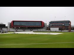 A general view of the covers and out-field as the start of play is delayed due to rain, during day one of a West Indies Warm Up match at Old Trafford in Manchester, England, yesterday ahead of their upcoming three-match Test series against the hosts.