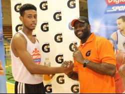 Jordan Kellier is being congratulated by Mitchell Watson, marketing manager of Pepsi Cola Jamaica, during the Gatorade/Digicel Sportsmax Jump Start Basketball clinic at the National Indoor Sports Centre.