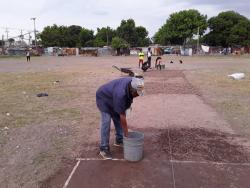 Team manager Ronny Lyons (foreground) works on a cricket pitch in the community of Majesty Gardens, otherwise called ‘Back-To’. Lyons is responsible for the creation of a new cricket team in the volatile community, which he hopes will help to stem violence in the area. 
