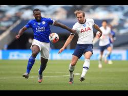 Leicester’s Wes Morgan (left) and Tottenham’s Harry Kane vie for the ball during their English Premier League match at the Tottenham Hotspur Stadium in London, England, on Sunday.