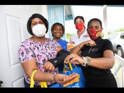 Marvette Johnson, (left), receives her keys from (from second left) Kivette Silvera, executive director of Food For the Poor (FFP) Jamaica; Christine Scott-Brown; executive director of National Baking Company Foundation (NBCF); and Nakia McMorris, senior manager for community development, Housing Agency of Jamaica, at the NBCF and FFP Jamaica Home Handover presentation to families in Portmore Villas, Old Road, in St Catherine last Thursday.