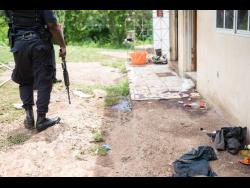 A policeman stands near the spot where one of six men were killed last Saturday. 