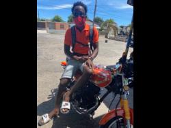 PNP supporter Junior Gayle shows off his orange motorbike. 