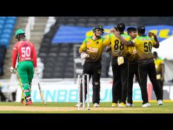 Sandeep Lamichhane (second right) and Glenn Phillips (second left)  of Jamaica Tallawahs celebrate the dismissal of Sherfane Rutherford (left) of Guyana Amazon Warriors during the Hero Caribbean Premier League match at the Brian Lara Cricket Academy last Saturday.