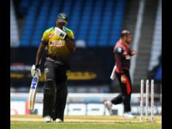 Nkrumah Bonner (left) of Jamaica Tallawahs walks off the field dismissed by Fawad Ahmed (right) of Trinbago Knight Riders during the Hero Caribbean Premier League semi-final between Jamaica Tallawahs and Trinbago Knight Riders at Brian Lara Cricket Academy yesterday in Tarouba, Trinidad and Tobago. The Knight Riders won by 9 wickets.