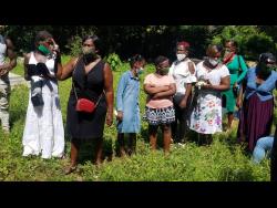 Mourners line up to get one look at Tamara Geddes in the coffin at the cemetery in Reserve, Trelawny.