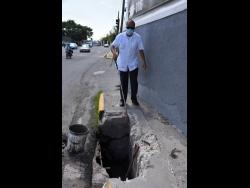 Vivian Blake shows how difficult it is for the visually impaired to navigate around this hole in the sidewalk.