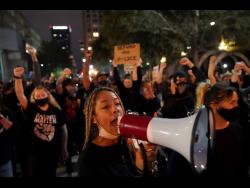 Protesters march on Thursday, in Louisville, Kentucky, USA. Authorities pleaded for calm while activists vowed to fight on in the state’s largest city, where a gunman wounded two police officers during protests following the decision not to charge officers for killing Breonna Taylor. 