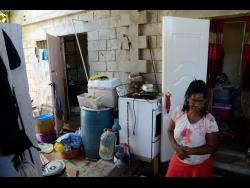 Marjorie Chin stands in one of the few covered sections of the living space.
