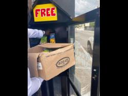 Credit: Akera Davis A donor places food items in the drop box.