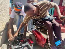 Lennox Edwards (right) fixing a motorised wheelchair at his home in Dunkirk, Kingston. 
