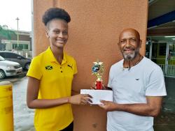 Clarendon businessman Andrew ‘Nazi’ Mattrasingh presents a scholarship package to Ruddayne Peters. 