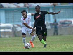 File
Fakibi Farquharson (right) of Molynes United FC dribbles past  Arnett Gardens FC’s Odane Samuels  during a Premier League encounter at the Waterhouse Stadium on September 22 last year.