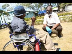 Desmond McKenzie, the minister of local government, talks to a resident of the Golden Age Home in Vineyard Town, Kingston, on March 30, a few weeks after Jamaica recorded its first COVID-19 case.