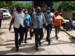 Leader of the Opposition, Mark Golding (centre), in Gordon Town where he viewed the effects of land slippage in Stand Up Hill. Golding toured sections of St Andrew that have been severely impacted by heavy rains.