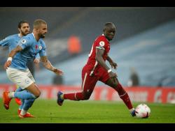 Liverpool’s Sadio Mane runs with the ball past Manchester City’s Kyle Walker (left) during the English Premier League  match between Manchester City and Liverpool at the Etihad stadium in Manchester, England, Sunday, November 8, 2020.