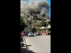 A massive plume of smoke to rises from a residence along Duke Street, Falmouth, Trelawny on Saturday.