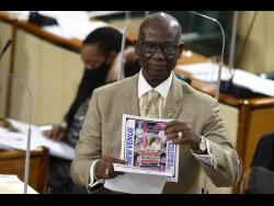Local Government Minister Desmond McKenzie holds up a flyer for an event advertised for today, that has not received the necessary permits from the Kingston and St Andrew Municipal Corporation. 