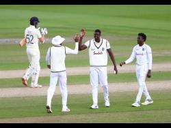 West Indies’ captain Jason Holder, second right, celebrates with teammates the dismissal of England’s Dom Sibley, left, during the third day of the third cricket Test match between England and West Indies at Old Trafford in Manchester, England, Sunday, July 26, 2020. 