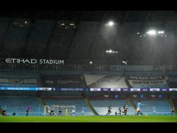 Players in the torrential rain during the English Premier League match between Manchester City and Newcastle United at the Etihad Stadium in Manchester on Saturday, December 26. 