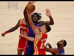 Bogdan Bogdanovic of the Atlanta Hawks tries to lay up a shot against Detrot Pistons’ Isaiah Stewart in the second half of a NBA match at the State Farm Arena in Atlanta, Georgia, on December 28, 2020.  
