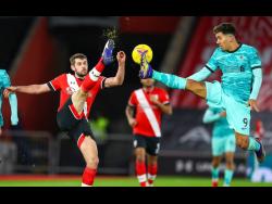 Southampton’s Jack Stephens, left, and Liverpool’s Roberto Firmino compete for the ball during the English Premier League match between Southampton and Liverpool at St Mary’s Stadium, Southampton, England, yesterday.