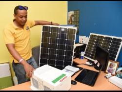 Kevin Mills, renewable energy specialist, owner of REDIS Renewable Energy Design and Installation Services, checks equipment before installation.