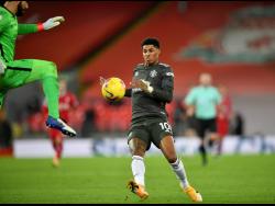 Liverpool’s goalkeeper Alisson clears the ball away from Manchester United’s Marcus Rashford during their English Premier League match at Anfield Stadium, Liverpool, England, yesterday.
