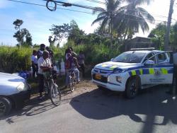 Residents catch water on the property in Frome under the watchful eyes of the police.